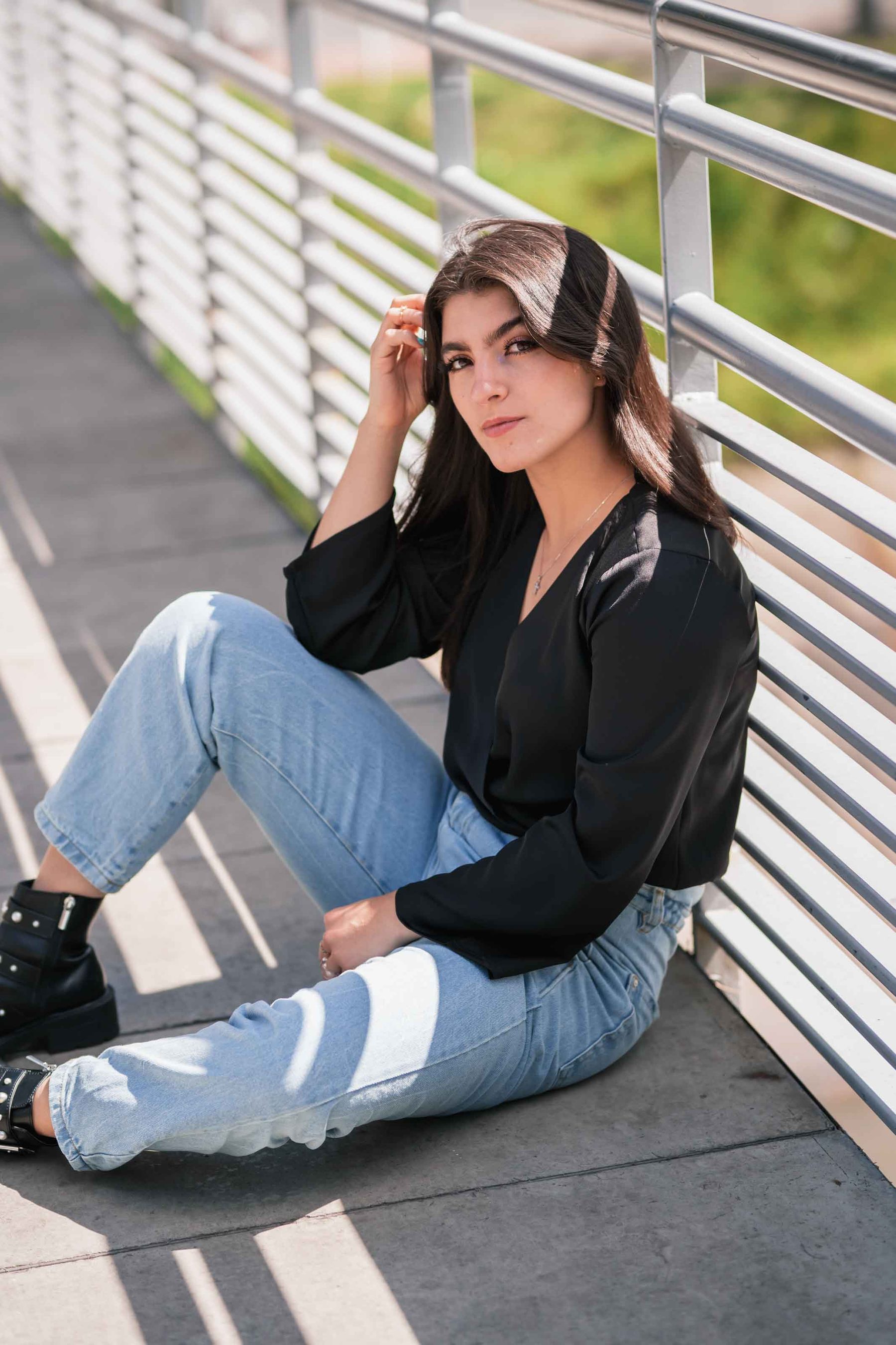 Woman in black seated by a metal grid