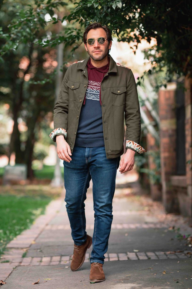 Man in a green jacket under a tree