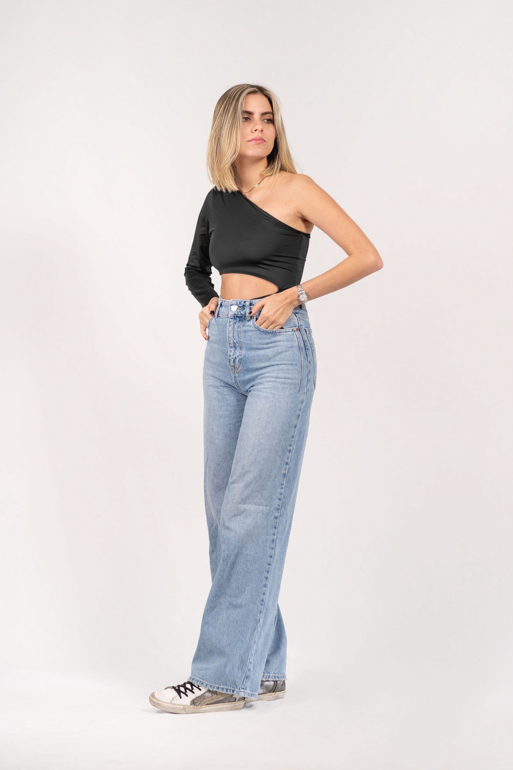 Model in a black one-shoulder top and wide jeans, full length