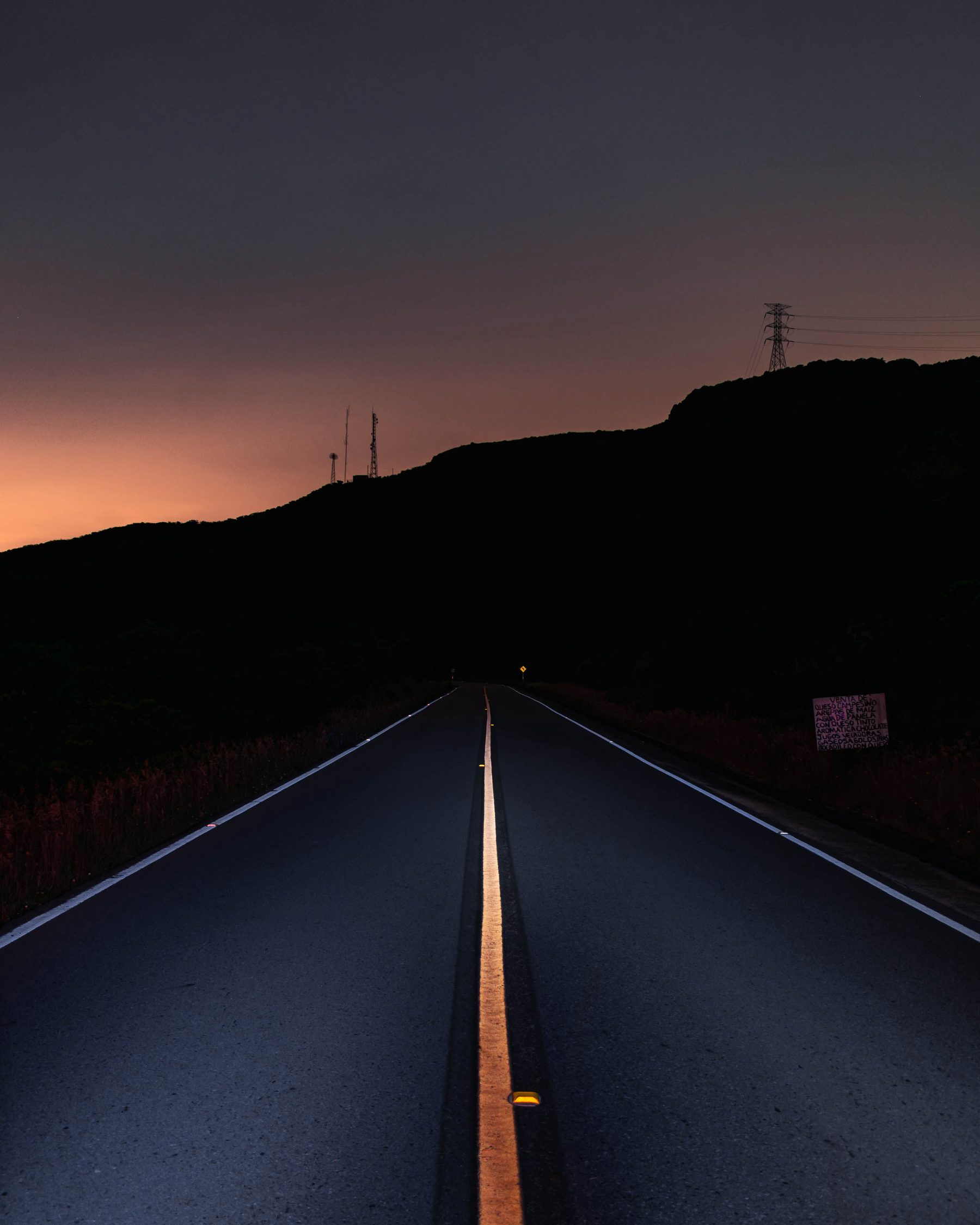 Road at night with a single lit line