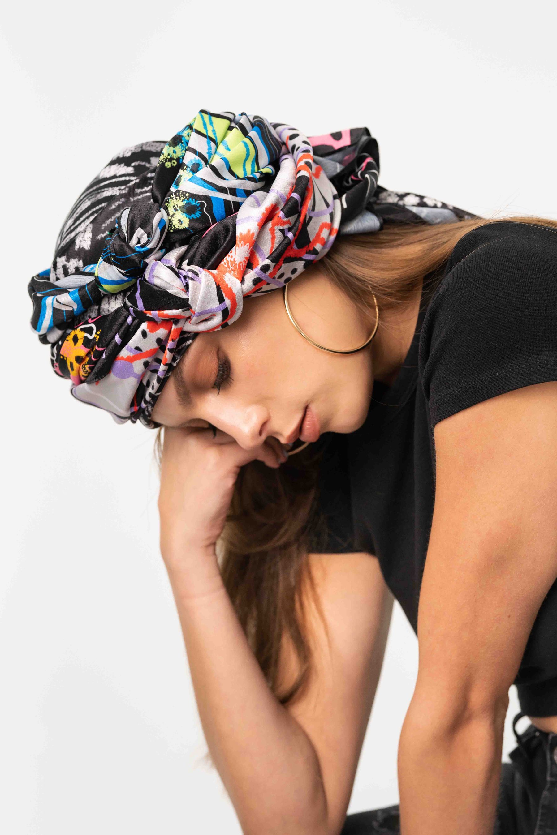 Model in a printed headscarf, head down