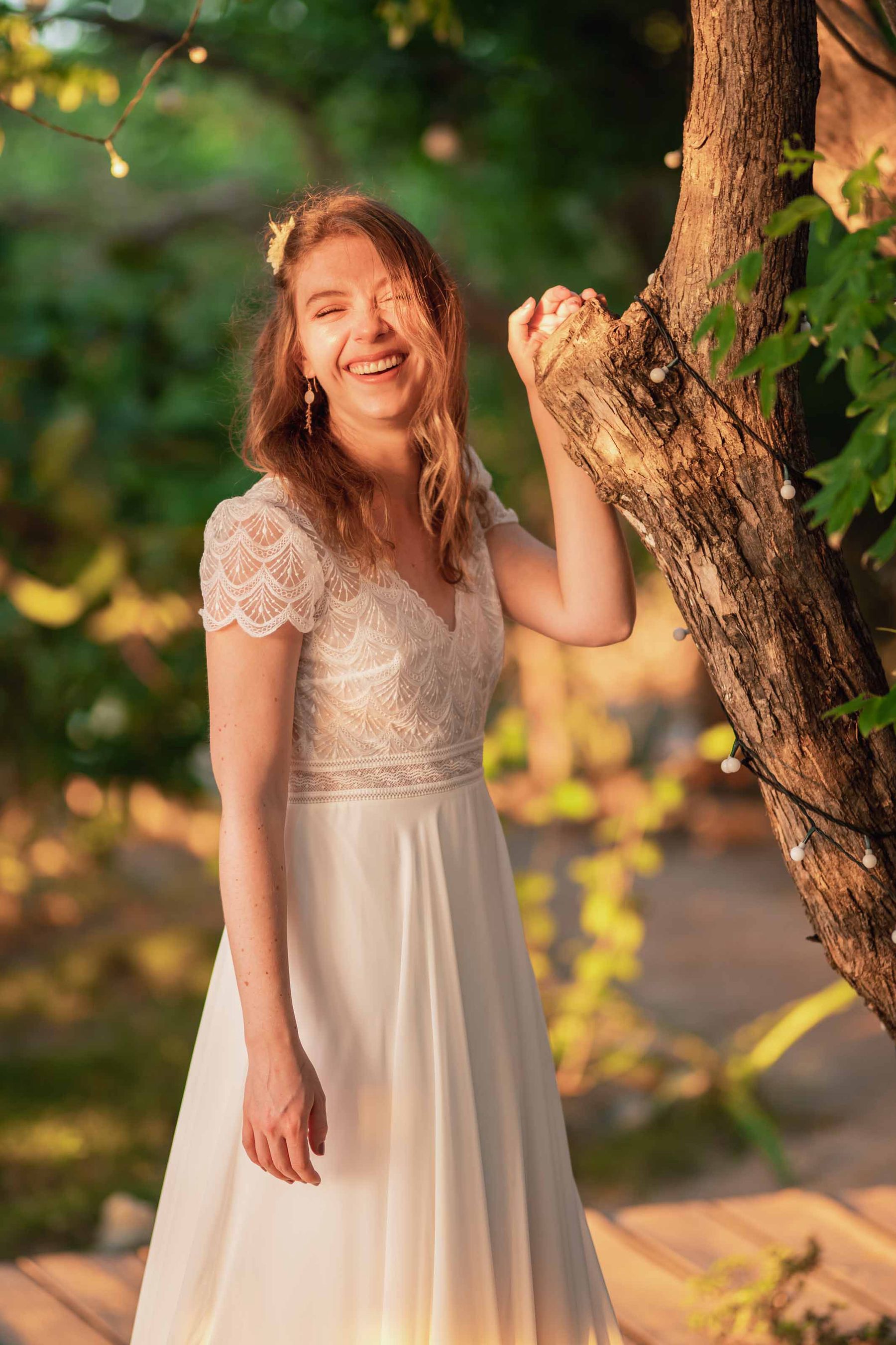 Bride laughing under the trees